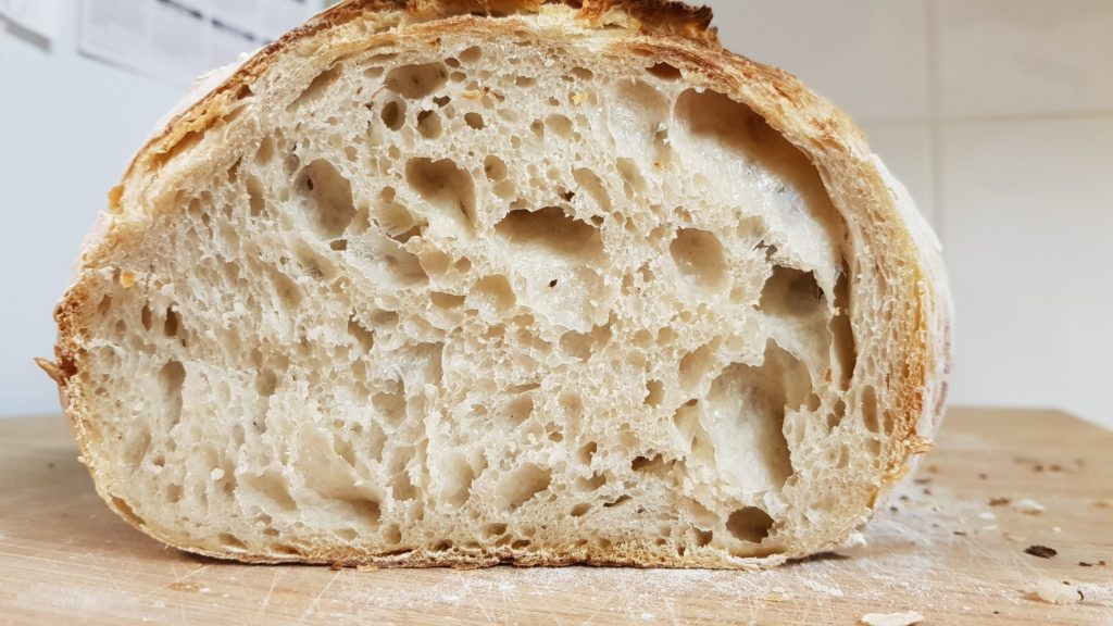 San Francisco Sourdough Bread cut in half and showing the inside to the camera